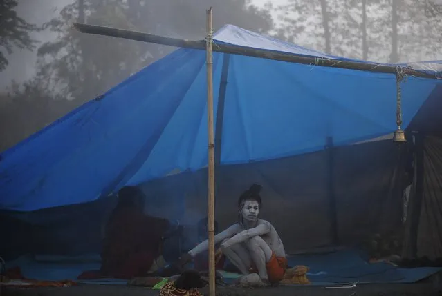 A Hindu holy man or “Sadhu” sits near a fire to keep himself warm on the first day of Swasthani Brata Katha festival in Kathmandu January 5, 2015. (Photo by Navesh Chitrakar/Reuters)