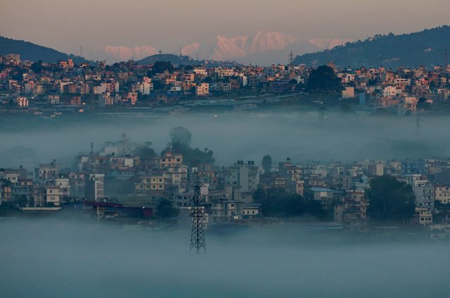 A snowcapped mountain range emerges over the valley during a foggy morning in Katmandu, Nepal on October 11, 2025. (Photo by Navesh Chitrakar/Reuters)