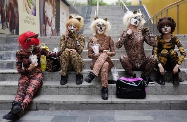 Volunteers in animal costumes wait to perform in an event to promote a love for dogs, in Beijing's Sanlitun area, June 20, 2013. Dog lovers and animal rights activists have called for the cancellation of an annual dog meat festival scheduled to take place on Friday in Yulin, Guangxi Zhuang autonomous region, voicing concerns over animal cruelty and food safety, according to China Daily. (Photo by Jason Lee/Reuters)