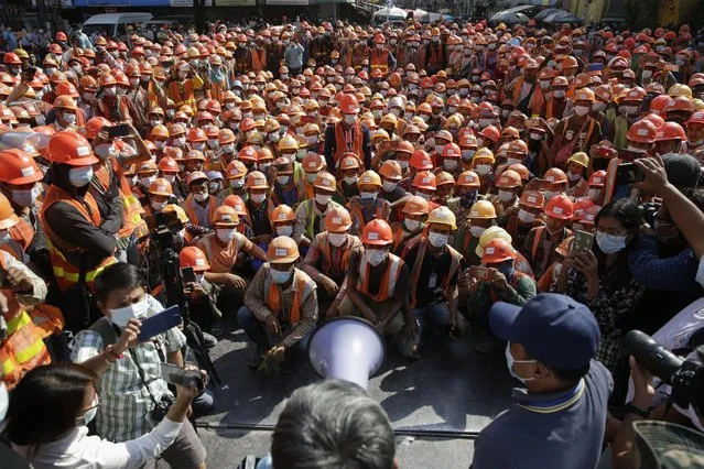 Construction workers gather as they protest to demand recognition of their labour rights at the downtown area in Yangon, Myanmar, 19 January 2021. Hundreds of workers came out from a construction site and staged a protest to demand recognition of their rights as laborers. (Photo by Lynn Bo Bo/EPA/EFE)