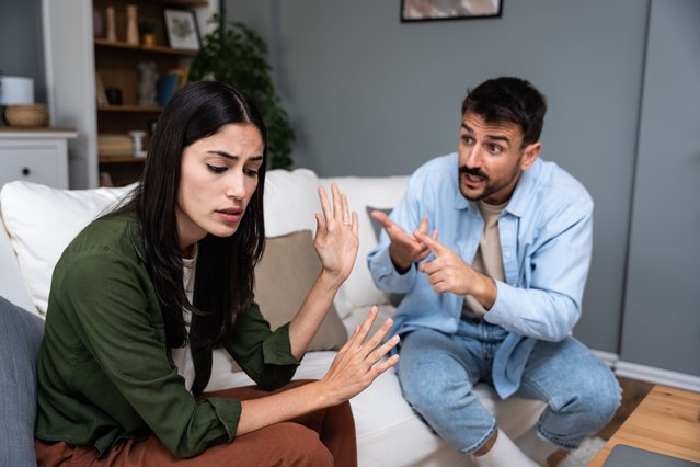 Young married couple husband and wife sitting at home having problems in their marriage and a cold relationship. A boyfriend and a girlfriend roommates have an argument about spending too much money. (Photo by Srdjanns74/Getty Images)