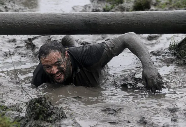 A competitor takes part in the Christmas Really Wild Mud Run on a 4.6 miles course across undulating farm land at Celtic Camping, St David's, Pembrokeshire, Wales, December 12, 2015. (Photo by Rebecca Naden/Reuters)