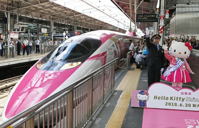 A Hello Kitty-themed “shinkansen” bullet train is unveiled at JR Shin Osaka station, in Osaka, western Japan, Saturday, June 30, 2018. The special shinkansen had its inaugural round trip Saturday between Osaka and Fukuoka, connecting Japan’s west and south until the end of September. The stylish train is painted pink and white, showcasing Hello Kitty images and trademark ribbons from flooring to seat covers and windows.  (Photo by Kyodo News via AP Photo)