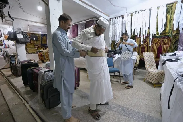 A pilgrim buys a money belt at a Hajj training center in Karachi, Pakistan, Monday, June 19, 2023. Saudi Arabia is hosting its biggest Hajj pilgrimage in three years, starting Monday. But for many pilgrims and others who couldn't make it, global inflation and economic crises made it more of a strain to carry out Islam's spiritual trip of a lifetime. (Photo by Fareed Khan/AP Photo)