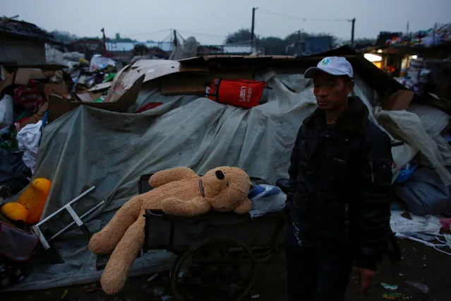 A man walks past a discarded teddybear soft toy at a recycling yard at the edge of Beijing, China, October 20, 2016. (Photo by Thomas Peter/Reuters)