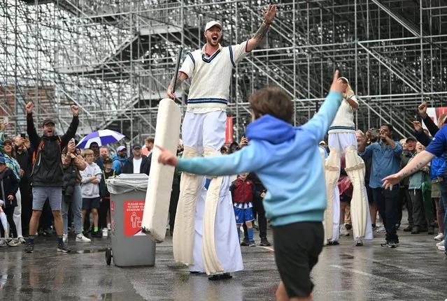 An entertainer on stilts plays cricket with cricket fans as play is delayed because of rain during day five of the LV= Insurance Ashes 4th Test Match between England and Australia at Emirates Old Trafford on July 23, 2023 in Manchester, England. (Photo by Stu Forster/Getty Images)