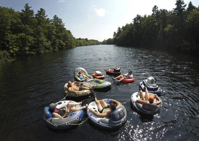 A flotilla of friends from Biddeford, Maine, raft down the Saco River at Bar Mills in Buxton, Maine, Sunday, August 26, 2018. Temperatures are expected to hover around the 90s for the next few days, making for the possibility of a heat wave in the week before Labor Day. (Photo by Robert F. Bukaty/AP Photo)