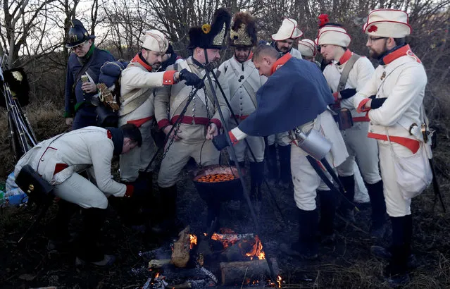 Historical re-enactment enthusiasts dressed as soldiers cook ahead of a re-enactment of Napoleon's famous battle of Austerlitz, that will take place tomorrow, near the southern Moravian village of Herspice, Czech Republic December 2, 2016. (Photo by David W. Cerny/Reuters)