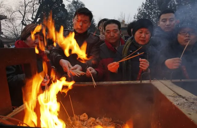 People burn incense as they pray for good fortune on the first day of the Chinese Lunar New Year at Yonghegong Lama Temple, in Beijing, February 19, 2015. (Photo by Kim Kyung-Hoon/Reuters)