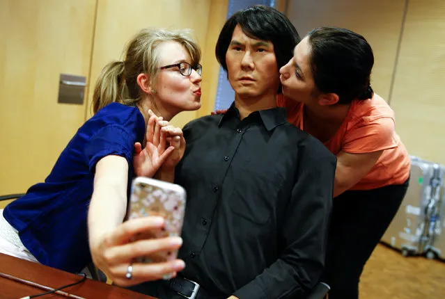 Employees of Germany's biggest retailer Metro AG take a selfie as they kiss HI-4, a life-size humanoid robot, at Metro's headquarters in Duesseldorf, Germany, June 7, 2016. The android, modelled after its Japanese inventor Hiroshi Ishiguro, a professor at Osaka's University, is made of a metal skeleton, plastic skull and silicon skin; and can be used as a human substitute for interaction via a tele-operated control system. (Photo by Wolfgang Rattay/Reuters)