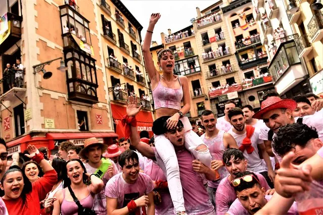 Revelers celebrate while waiting for the launch of the “Chupinazo” rocket, to mark the official opening of the 2022 San Fermin fiestas in Pamplona, Spain, Wednesday, July 6, 2022. The blast of a traditional firework opens Wednesday nine days of uninterrupted partying in Pamplona's famed running-of-the-bulls festival which was suspended for the past two years because of the coronavirus pandemic. (Photo by Alvaro Barrientos/AP Photo)