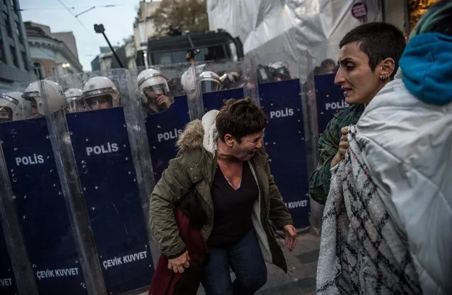 Protestors react after Turkish anti riot police used tear gas against women's rights activists who try to march to Taksim Square to protest against gender violence in Istanbul, on November 25, 2018, on the International Day for the Elimination of Violence against Women. (Photo by Bulent Kilic/AFP Photo)