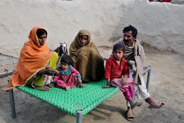 In this Wednesday, December 21, 2016 photo, Wazir Ahmed, right, who married his underage daughter to a 36 year-old man, sits with his wives in Jampur, Pakistan. The marriage was in exchange for a second wife who is the man's sister. He hopes she will give him a son. He says he feels no remorse because tradition and faith demands parents marry their daughters, who he calls burdens, soon after they reach puberty. (Photo by K.M. Chaudhry/AP Photo)