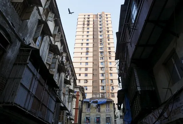 A high-rise residential tower is pictured behind old residential buildings in Mumbai, India, January 25, 2016. (Photo by Danish Siddiqui/Reuters)