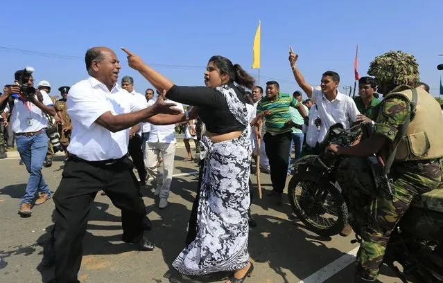 A Sri Lankan woman supporting the government's initiative of setting up an industrial zone project argues with Buddhist monks and villagers protesting against it at Mirijjawila village in Ambalantota, Sri Lanka, Saturday, January 7, 2017. Sri Lankan police used water cannons to try to break up violent clashes Saturday between government supporters and villagers marching against what they say is a plan to take over private land for an industrial zone in which China will have a major stake. The government has signed a framework agreement for a 99-year lease of the Hambantota port with a company in which China will have 80-percent ownership. Officials also plan to set up the nearby industrial zone where Chinese companies will be invited to set up factories. (Photo by Eranga Jayawardena/AP Photo)
