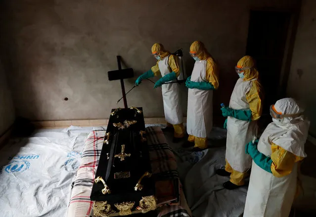 A healthcare worker sprays a room during a funeral of  Kavugho Cindi Dorcas who is suspected of dying of Ebola in Beni, North Kivu Province of Democratic Republic of Congo, December 9, 2018. (Photo by Goran Tomasevic/Reuters)