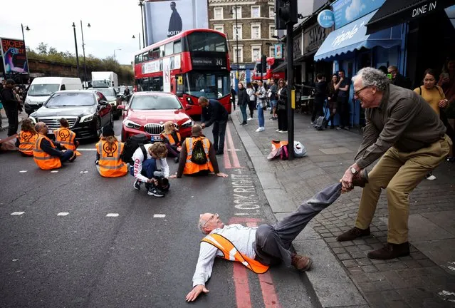 A member of the public drags an activist who is blocking the road during a “Just Stop Oil” protest, in London, Britain on October 15, 2022. (Photo by Henry Nicholls/Reuters)