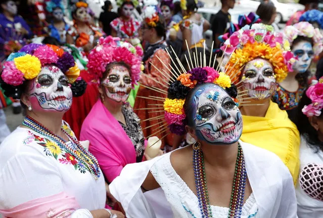 Women dressed in the costume of La Catrina parade down a main avenue of Mexico City, Mexico, 23 October 2022. The parade was a prelude to Day of the Dead celebrations, which will be held on the first days of November. (Photo by Mario Guzman/EPA/EFE)