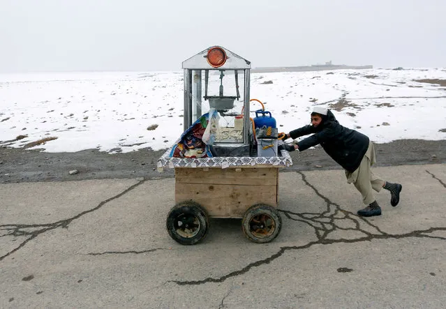 An Afghan boy pushes a popcorn machine as he looks for customers, on the outskirts of Kabul, Afghanistan January 17, 2017. (Photo by Mohammad Ismail/Reuters)