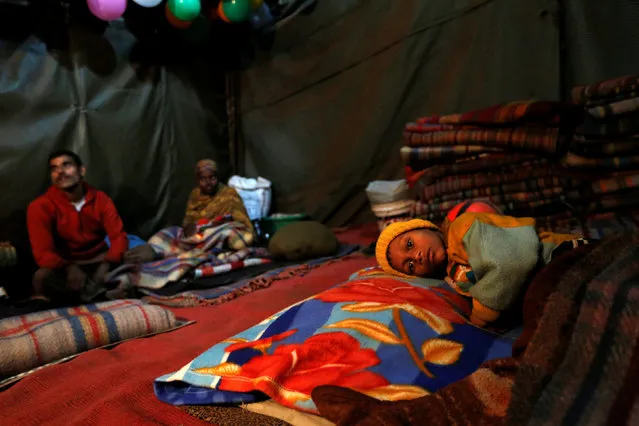 A child rests in a government shelter for homeless people to escape the cold in Delhi, India January 16, 2017. (Photo by Cathal McNaughton/Reuters)