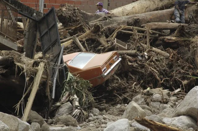 A car lays amid the debris left behind by flooding and landslides triggered by torrential rains in the Tovar municipality of Merida state, Venezuela, Thursday, August 26, 2021. (Photo by Luis Bustos/AP Photo)
