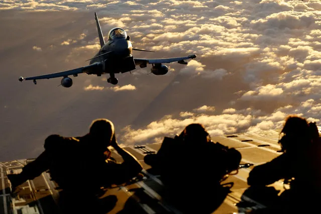 Several soldiers from the Spanish Air Force observe a Eurofighter EF-2000 fighter aircraft of the Spanish Air Force, as it flies during the Ocean Sky 2023 Military Exercise for advanced air-to-air training in the southern airspace of the Canary Islands, Spain on October 25, 2023. (Photo by Borja Suarez/Reuters)