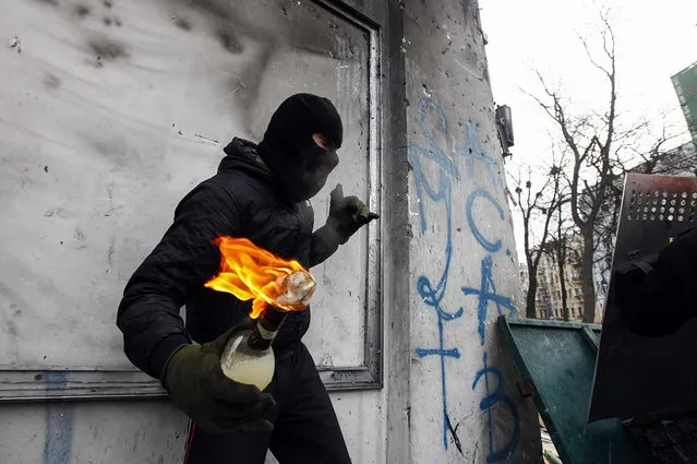 A pro-European integration protester carries a Molotov cocktail during clashes with police in Kiev January 20, 2014. (Photo by Vasily Fedosenko/Reuters)