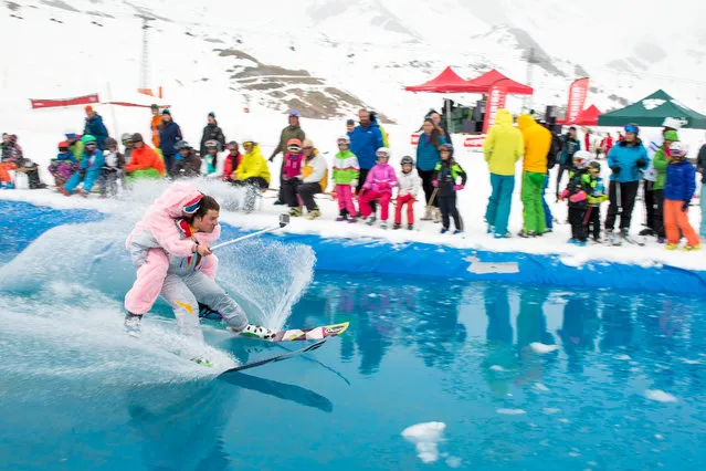 Two skiers participate in a water sliding contest, in which athletes are gliding over a pool embedded in snow, in Verbier, southwestern Switzerland, Saturday, April 25, 2015. (Photo by Maxime Schmid/Keystone via AP Photo)
