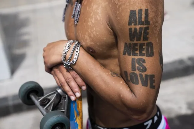 Skater Christoper Melgar watches security forces during a protest against food scarcity affecting community soup kitchens in Buenos Aires, Argentina, Thursday, February 8, 2024. (Photo by Rodrigo Abd/AP Photo)