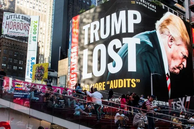 A billboard showing former U.S. President Donald Trump is seen as people visit Times Square in the Manhattan borough of New York, New York, U.S., October 14, 2021. (Photo by Eduardo Munoz/Reuters)