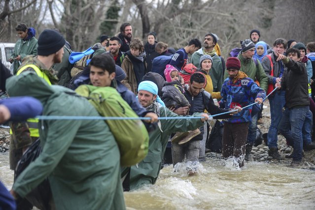 Migrants from a camp near Idomeni village, cross the river trying to find alternative way to cross the Greek-Macedonian border, near Idomeni, northern Greece, 14 March 2016. (Photo by Nake Batev/EPA)