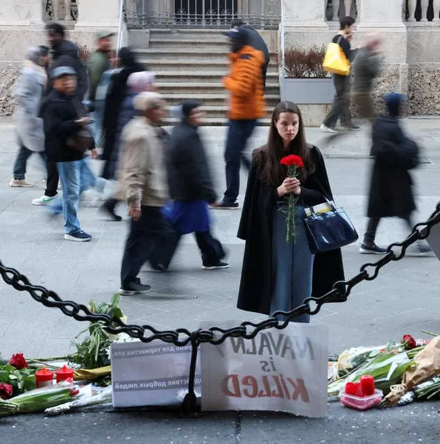 A woman holds flowers in front of a makeshift memorial to Russian opposition leader Alexei Navalny in Milan, Italy on February 19, 2024. (Photo by Claudia Greco/Reuters)