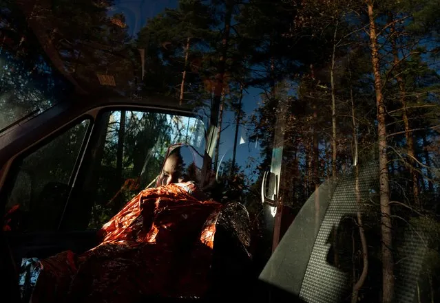 A migrant from Somalia sits in an ambulance as she crosses the Belarusian-Polish border in Siemianowka, Poland on October 25, 2021. (Photo by Kacper Pempel/Reuters)