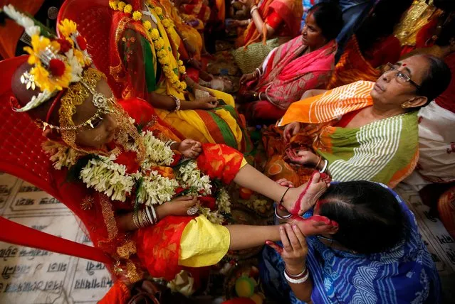 A devotee touches the feet of a girl dressed as Kumari to seek blessings during rituals to celebrate the Hindu festival of Navrati inside the Adyapeath temple on the outskirts of Kolkata, India, April 14, 2019. (Photo by Rupak De Chowdhuri/Reuters)