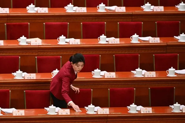 An attendant cleans before the second plenary session of the 14th National People's Congress (NPC) at the Great Hall of the People in Beijing on March 8, 2024. (Photo by Pedro Pardo/AFP Photo)