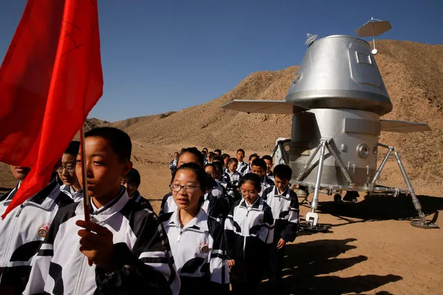 Students leave a mock space capsule after a lesson at the C-Space Project Mars simulation base in the Gobi Desert outside Jinchang, Gansu Province, China,  April 17, 2019. (Photo by Thomas Peter/Reuters)