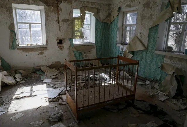 A baby cot is seen in a house in the abandoned village of Zalesye near the Chernobyl nuclear power plant in Ukraine on March 28, 2016. (Photo by Gleb Garanich/Reuters)