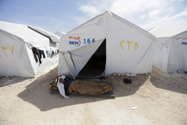 An internally displaced man sleeps in the shade of a tent inside a refugee camp in Dana town after fleeing Palmyra, in northern Idlib province, Syria April 2, 2016. (Photo by Khalil Ashawi/Reuters)
