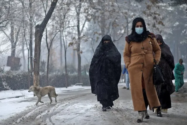 Afghan women walk on the street during a snowfall in Kabul, Afghanistan, January 3, 2022. (Photo by Ali Khara/Reuters)