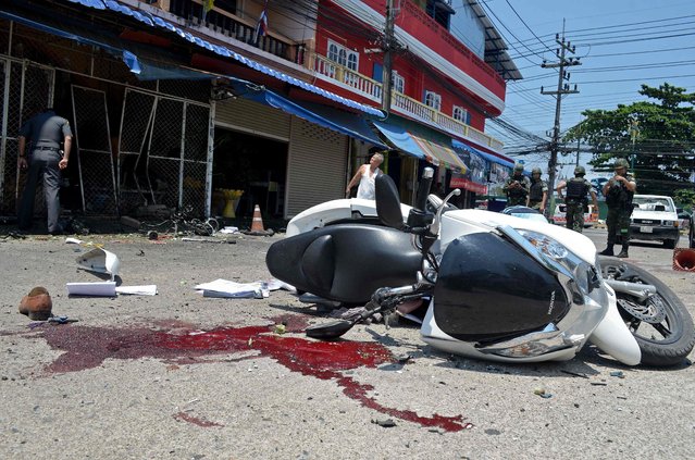 Thai bomb squad members inspect the site of a motorcycle bomb attack which injured 13 people in Thailand's restive southern province of Narathiwat on April 25, 2016. More than 6,500 people have been killed – the majority civilians – since 2004 in clashes between militants and security forces from Thailand's Buddhist-majority state. (Photo by Madaree Tohlala/AFP Photo)