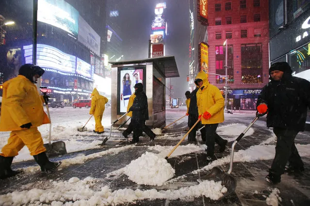 A crew of snow shovelers work as a snowstorm sweeps through Times Square, Tuesday, March 14, 2017, in New York. (Photo by Mark Lennihan/AP Photo)