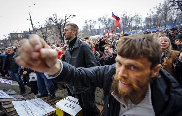 Pro-Russian protesters attend a rally in front of the seized office of the SBU state security service in Luhansk, eastern Ukraine April 14, 2014. Ukraine's president on Monday threatened military action after pro-Russian separatists occupying government buildings in the east ignored an ultimatum to leave and another group of rebels attacked a police headquarters in the troubled region. (Photo by Shamil Zhumatov/Reuters)