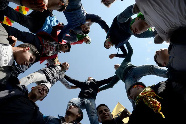 Turkish Kurds build a human tower during Newroz celebrations for the new year in Diyarbakir, southeastern Turkey, on March 21, 2017. Newroz (also known as Nawroz or Nowruz) is an ancient Persian festival, which is also celebrated by Kurdish people, marking the first day of spring, which falls on March 21. (Photo by Ilyas Akengin/AFP Photo)