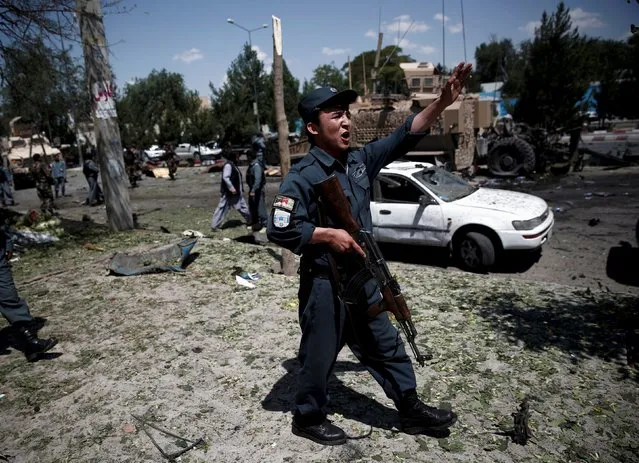 An Afghan policeman reacts at the site of a suicide bomb attack in Kabul, Afghanistan June 30, 2015. (Photo by Ahmad Masood/Reuters)