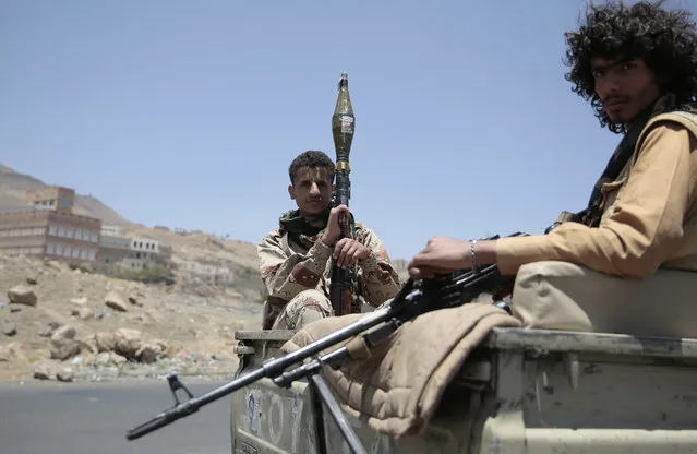 Shiite fighters, known as Houthis, secure a road, as people take part in a march, denouncing plans by the Arab coalition to attack Hodeidah, from Sanaa to the port city of Hodeidah, Yemen, Wednesday, April 19, 2017. (Photo by Hani Mohammed/AP Photo)