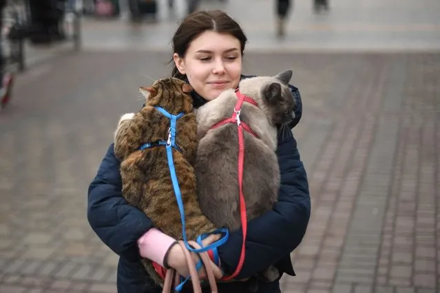 A woman carries her cats as she walks near Kyiv-Pasazhyrskyi railway station in Kyiv in the morning of February 24, 2022. Air raid sirens rang out in downtown Kyiv today as cities across Ukraine were hit with what Ukrainian officials said were Russian missile strikes and artillery. Russian President announced a military operation in Ukraine on February 24, 2022, with explosions heard soon after across the country and its foreign minister warning a “full-scale invasion" was underway. (Photo by Daniel Leal/AFP Photo)