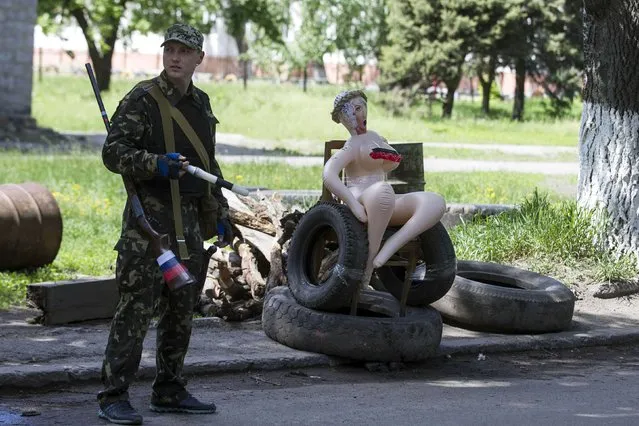 An armed pro-Russian man stands at a checkpoint in the town of Slovyansk on May 6, 2014. (Photo by Baz Ratner/Reuters)