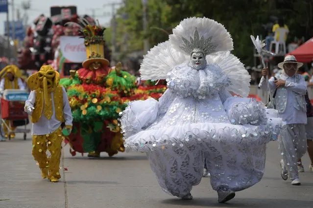 Revelers perform in the Battle of Flowers parade as part of Barranquilla's Carnival, Colombia, on March 26, 2022. (Photo by Raul Arboleda/AFP Photo)