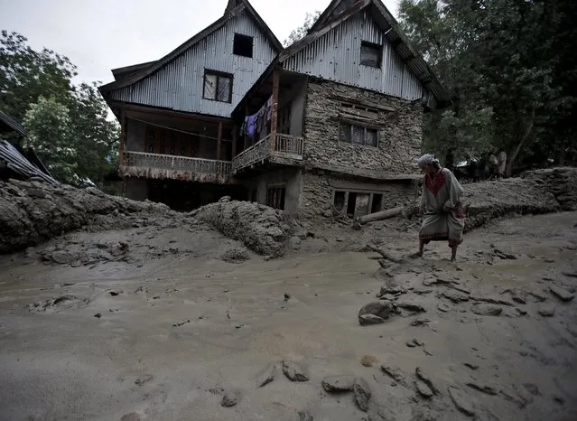 A Kashmiri woman walks through the cloud burst hit area of Kullan village in Ganderbal district, July 17, 2015. (Photo by Danish Ismail/Reuters)