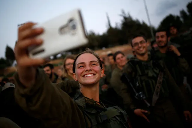 An Israeli soldier of the Search and Rescue brigade takes a selfie of her comrades during a training session in Ben Shemen forest, near the city of Modi'in May 23, 2016. (Photo by Amir Cohen/Reuters)